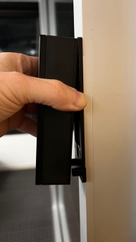 A hand holding a black rectangular object

Description automatically generated