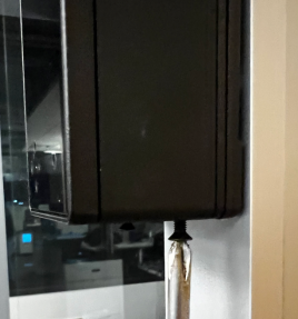 A black box with a clear plastic tube attached to it

Description automatically generated